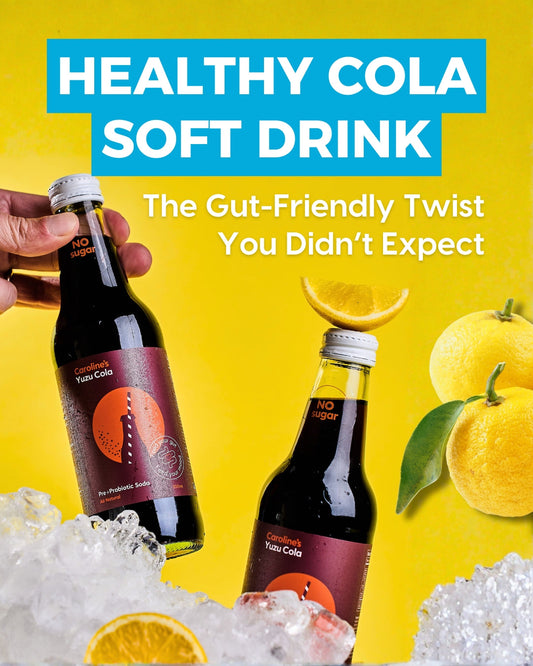 Bottle of Caroline’s Yuzu Cola surrounded by citrus slices and bubbles, promoting a healthy cola soft drink made with prebiotics and probiotics.